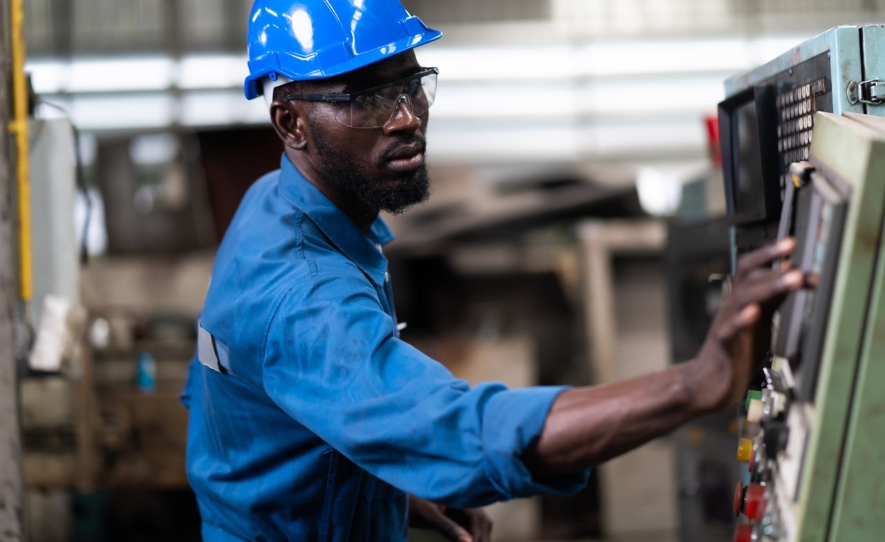 Male engineer working on machine in factory