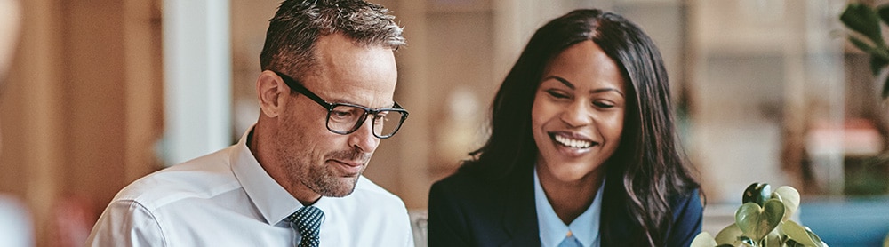 business people viewing laptop together