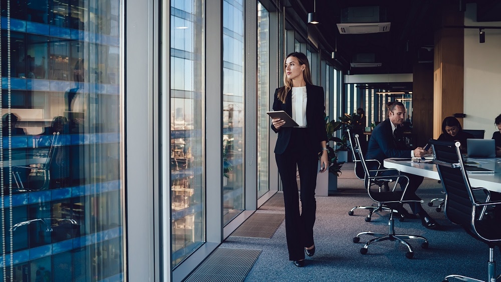 Consultant walking along windows in conference room