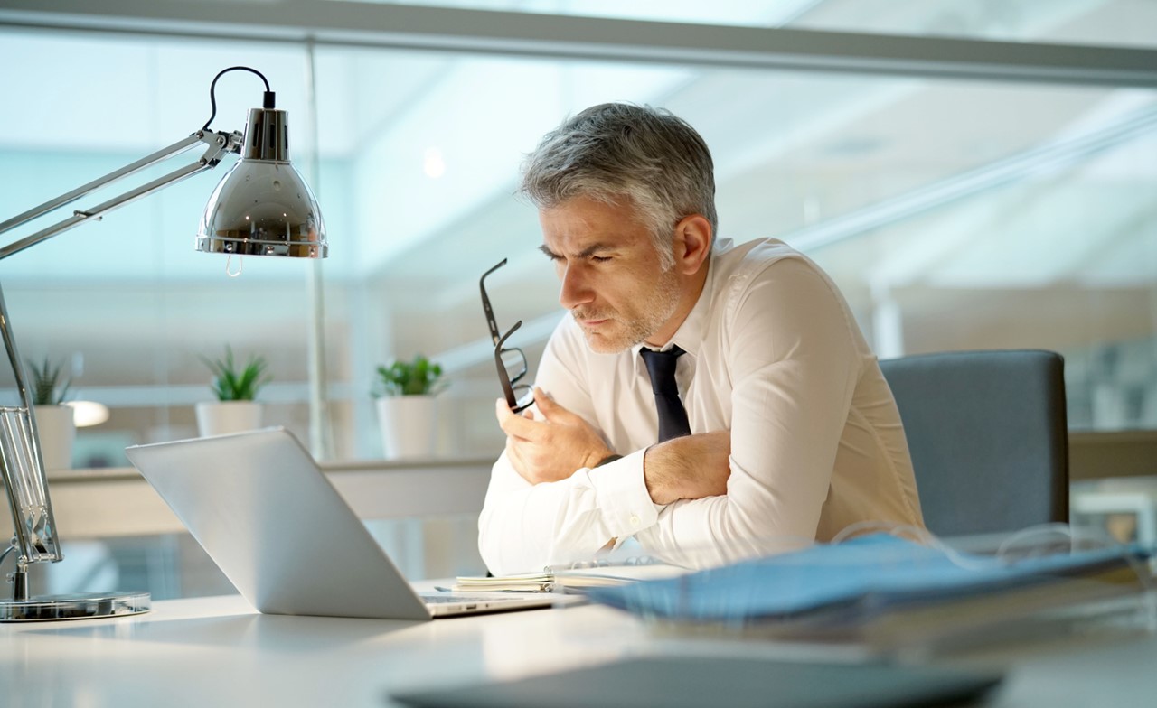 Executive overseeing corporate transaction banking on a laptop