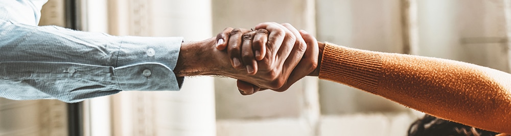 2 people extending their arms to hold hands