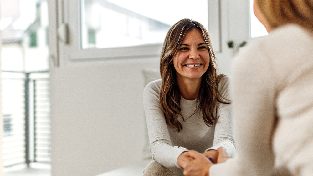 Kaksi naista istuu ja keskustelee