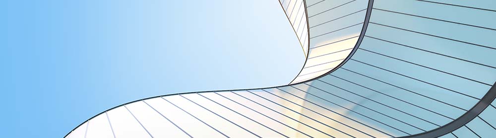 Upwards angle view of an abstract silver wave shape building and blue sky