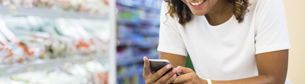 Person interacting on phone while grocery shopping