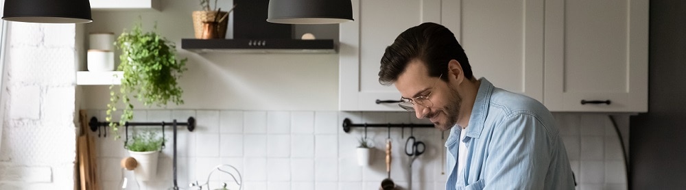 person working on laptop on kitchen counter