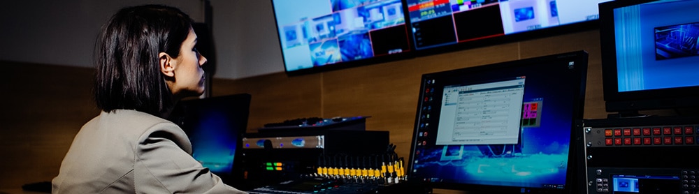 Person in tv studio adjusting the media screens 