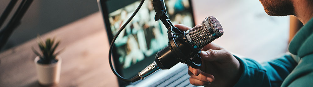 Professional in front of laptop speaking into microphone