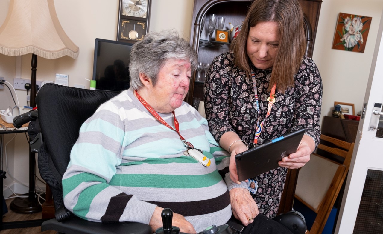 Social care worker showing patient something on tablet device