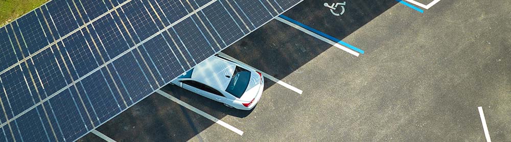 a car parked under a solar panel roof in a public lot