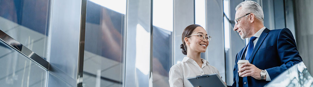 two-colleagues-discuss-report-in-stairwell-mobilecrop