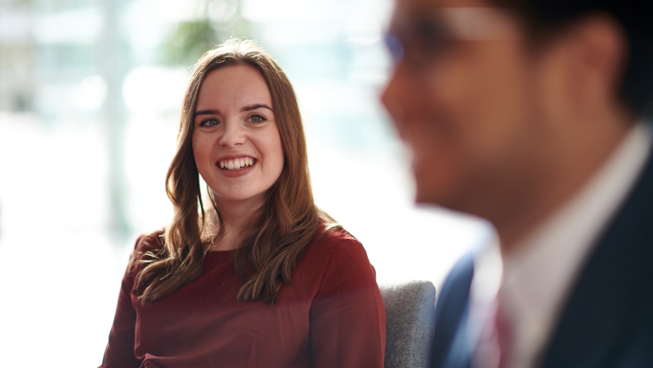 professional young woman smiling at male colleague