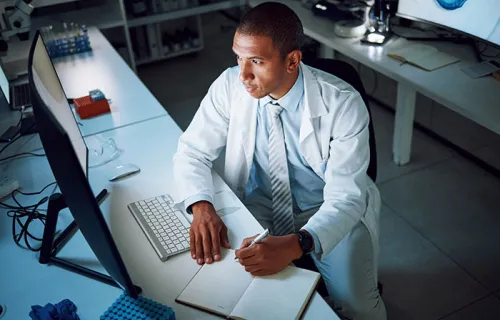 Doctor, writing and night with computer in laboratory for medical research and study with…