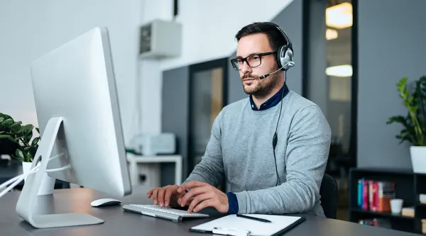 Man sitter vid en dator (AI)