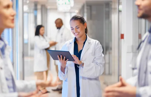 docor using tablet in hospital hallway