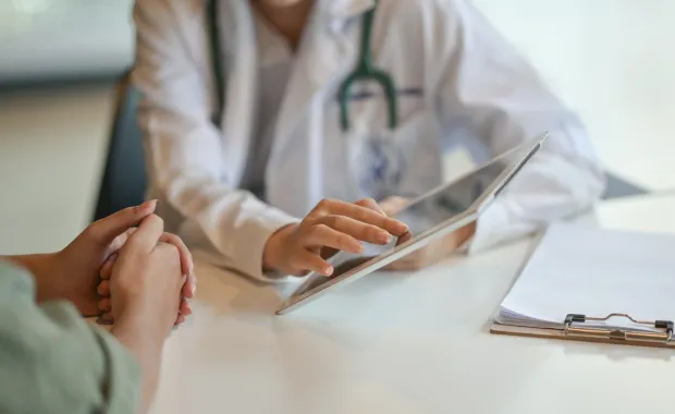Doctor's hands showing a patient information on a tablet