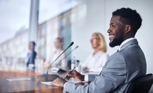 A group of people sitting at a table with microphones