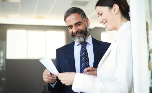 male and female executives standing and discussing