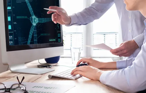 two people analyzing wind turbine data on a monitor