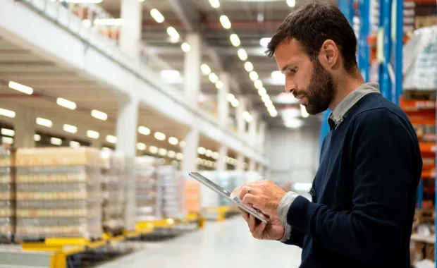 Manager holding a digital tablet in a warehouse
