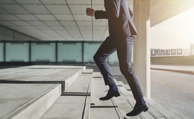 Person in a suit running up stairs