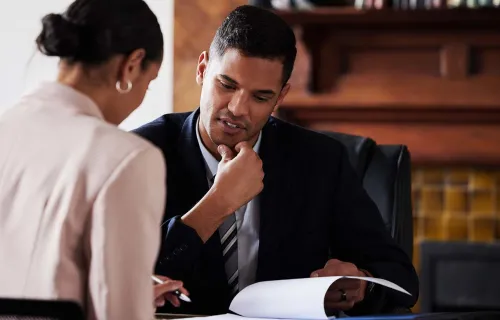Two colleagues overlooking a document