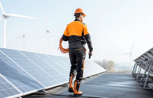 a worker inspects rooftop solar panels