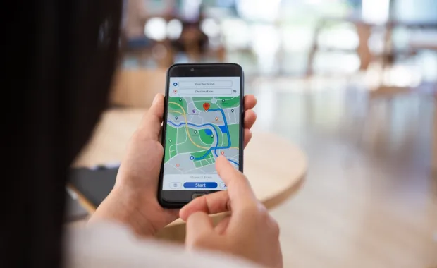 Hand of a woman searching for a location on a smartphone map application 